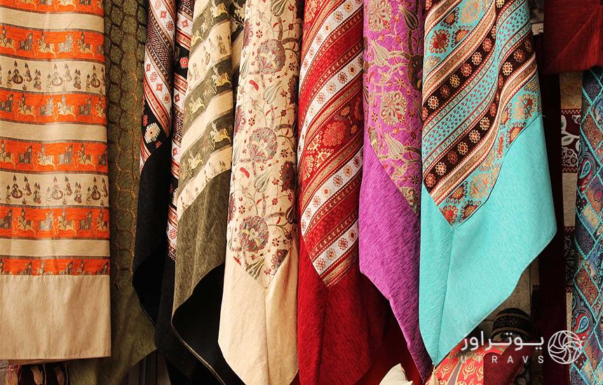 عکسی از نمای نزدیک از تعدادی شال پشمی عربی آویزان‌شده در رنگ‌‎های مختلف